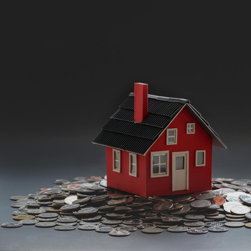 Real estate and property investment concept : small house model on stack of coins